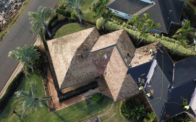 Aerial view of crew installing shingles for Hawaii home roof replacement, after the decision to replace rather than repair it.