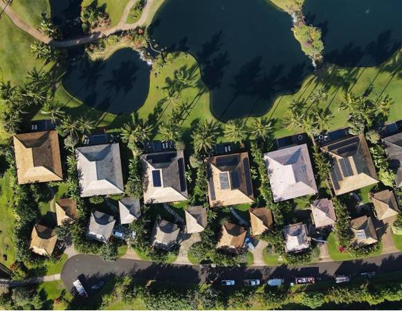 Drone view of a Hawaii neighborhood showing different roof colors and reflectivity in the tropical sun.
