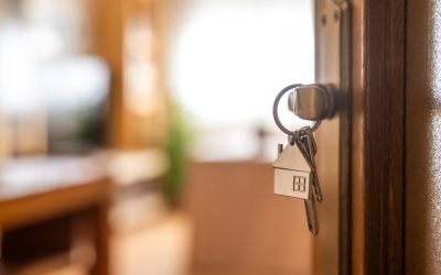 House keys with a home-shaped keychain in the door of a Hawaii house being sold